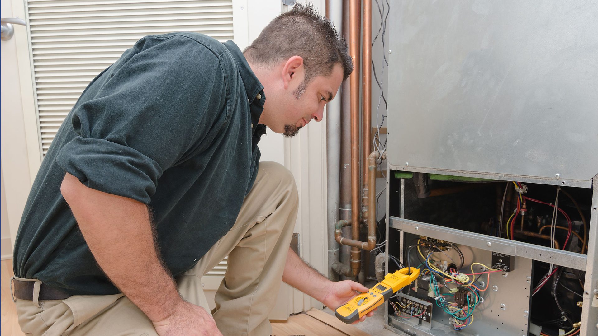 30559888 - hvac technician using a meter to check heat pump amperage